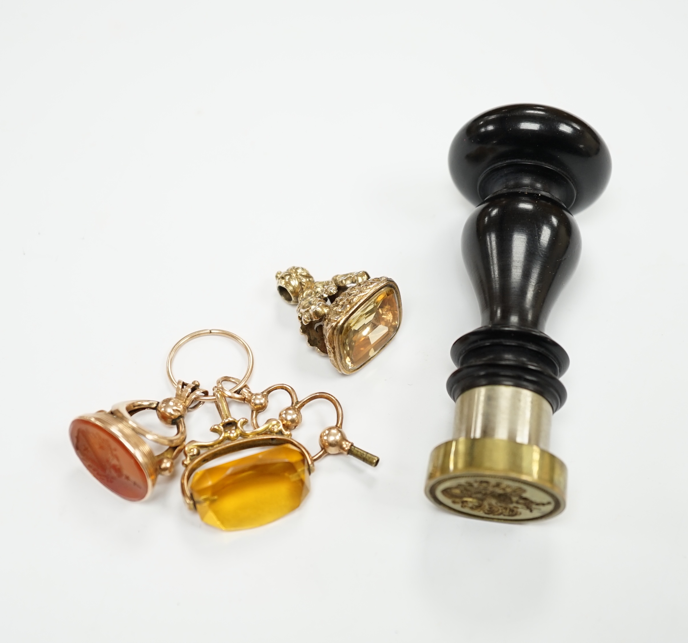 Two 19th century yellow metal overlaid fob seals, one with carnelian stone carved with a crest, 28mm, a base metal table seal and a pinchbeck seal.